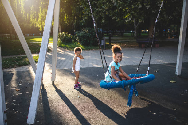 istock Gorgeous mixed race sisters playing on a swing 1024953686