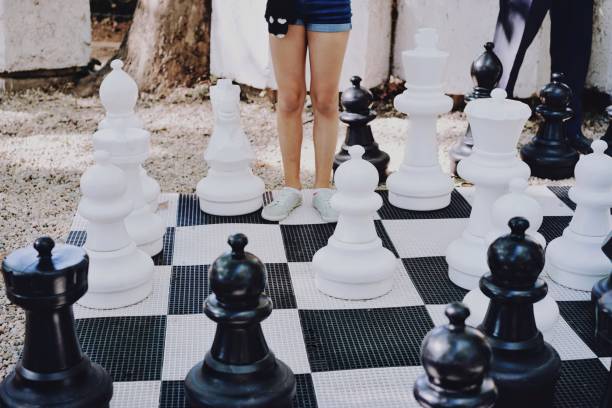 istock Low Section Of Woman Standing On Chess Board At Park 1024954216