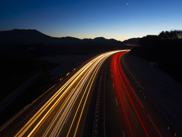 istock Car lights driven at speed by the highway 1024981690