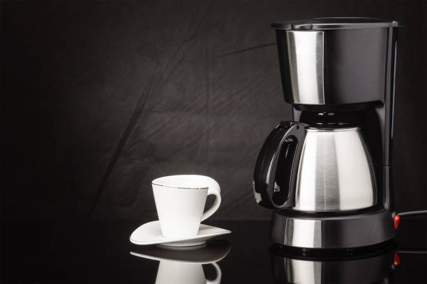 istock Coffee machine with pot and cup on the black mirror background 1024991340