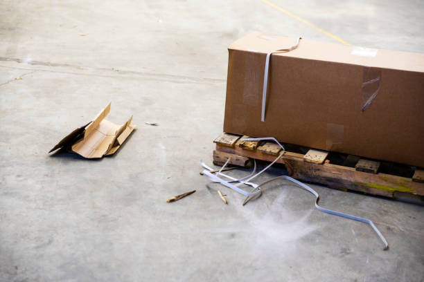 A broken wooden pallet with debris on a warehouse floor stock photo