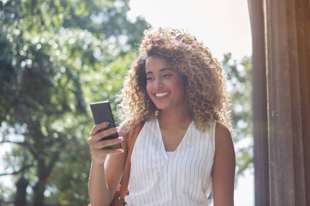 istock Young woman texts friend while sightseeing 1025006250