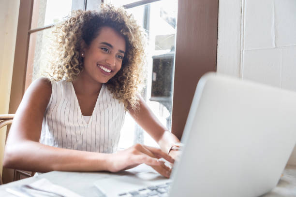istock Young businesswoman types on laptop at work 1025006256
