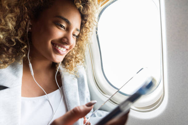 istock Young woman enjoys airline wireless technology 1025006294