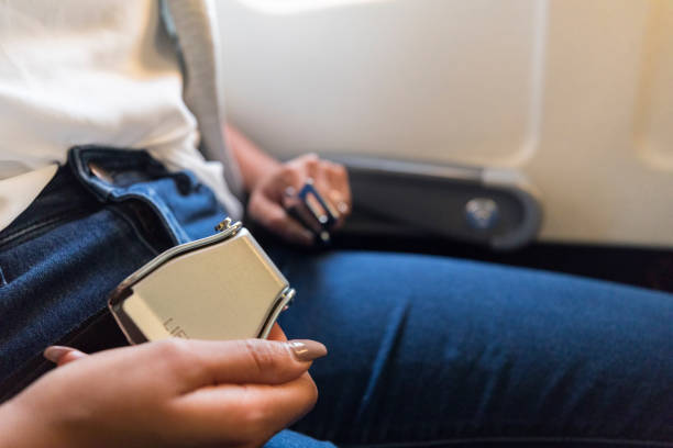 Unrecognizable woman fastens airline seatbelt