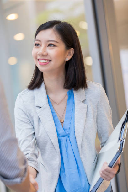 istock Cheerful Asian businesswoman greets client 1025006446