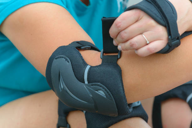 istock Woman rollerskater putting on elbow protector pads on her hand 1025009056