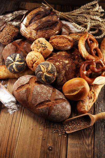 istock Different kinds of bread and bread rolls on board from above. Kitchen or bakery 1025043390