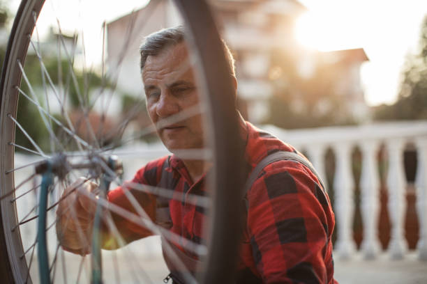 istock Mature man fixing bicycle wheel 1025060158