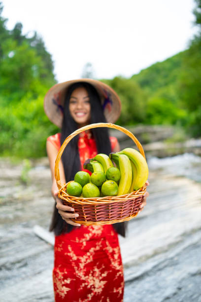 istock Young woman holding a baset with limes and bananas 1025067220