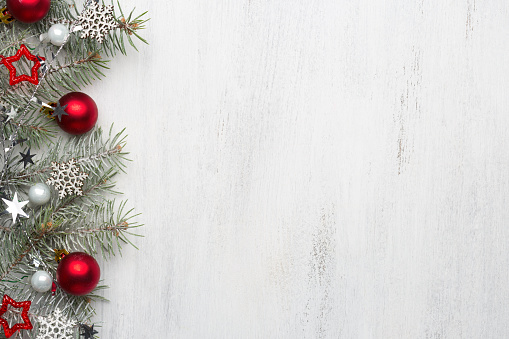 Fir branch with Christmas decorations on old wooden shabby background with copy space for text.