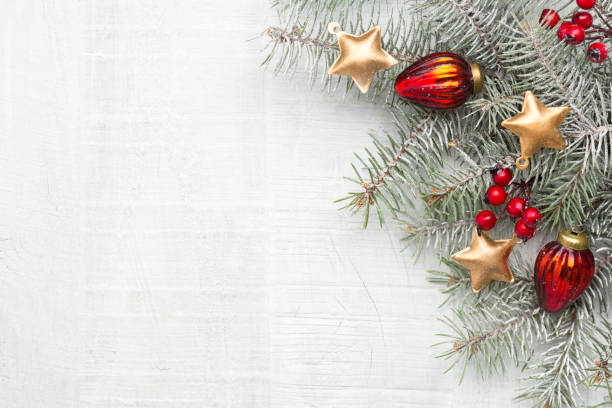 istock Fir branch with Christmas decorations on white rustic wooden background with copy space for text. 1025067786