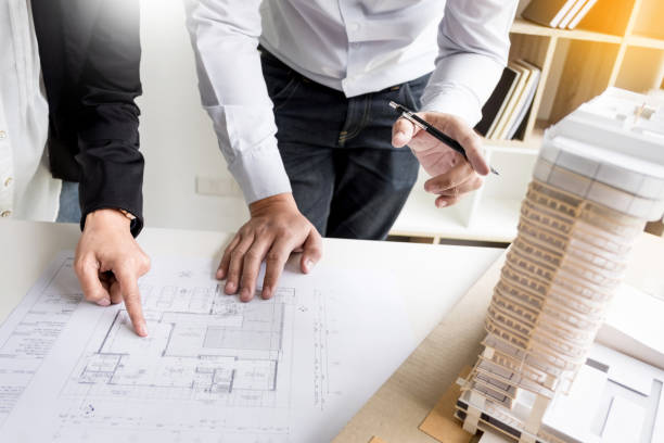 istock Midsection Of Business People Discussing Blueprint On Table In Office 1025071966