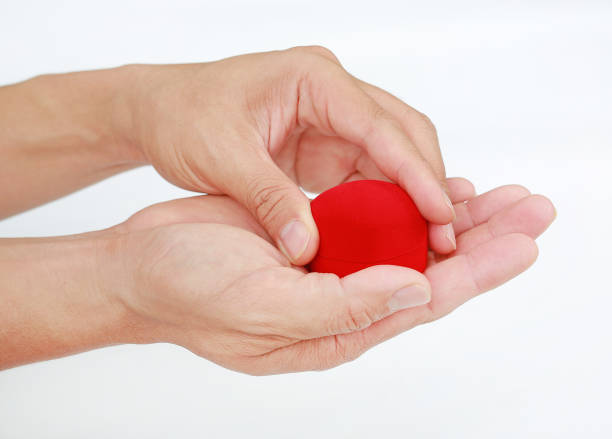 istock Hands holding small gift heart isolated on black background. 1025081842