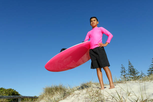 australian aboriginal boy at beach with surf rescue board - gold coast australia lifeguard sea imagens e fotografias de stock