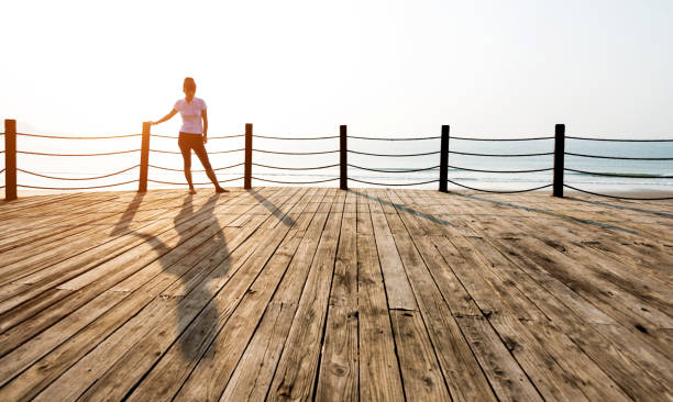 istock Woman standing on boardwalk at the beach 1025097288