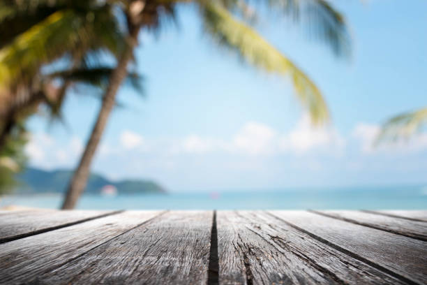 istock Empty wood table top and blurred Palm tree summer beach with blue sea and sky background. - can used for display or montage your products. 1025098440