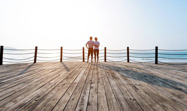 istock Couple standing on boardwalk at the beach 1025103474
