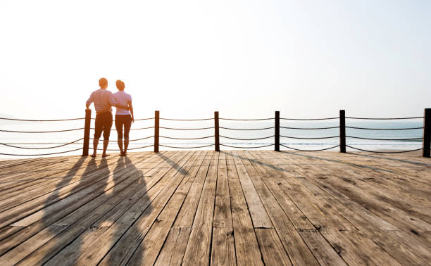 istock Couple standing on boardwalk at the beach 1025103476