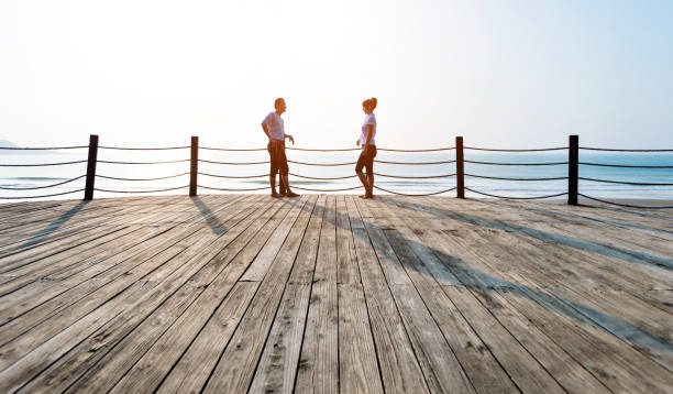 istock Couple standing on boardwalk at the beach 1025103834