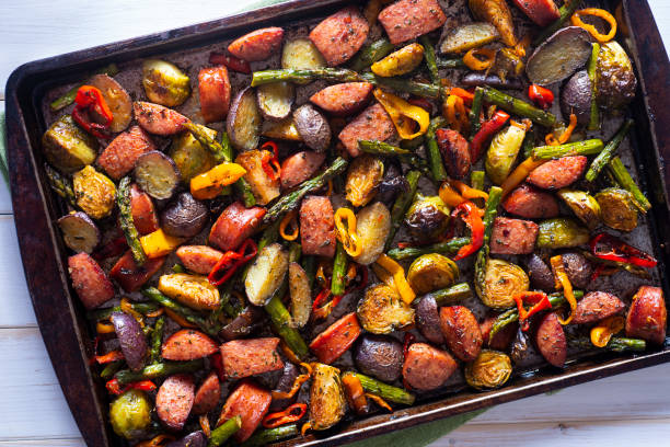 Sheet Pan Sausage Sausage Sheet Pan Dinner with Asparagus, Potatoes, Brussels Sprouts and Sweet Mini Peppers baking sheet stock pictures, royalty-free photos & images
