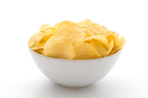 Potato chips in white bowl isolated on white background.