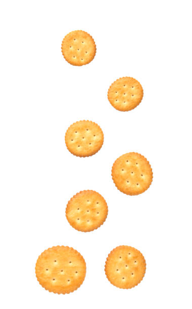 Round salted cracker cookies falling isolated on white background