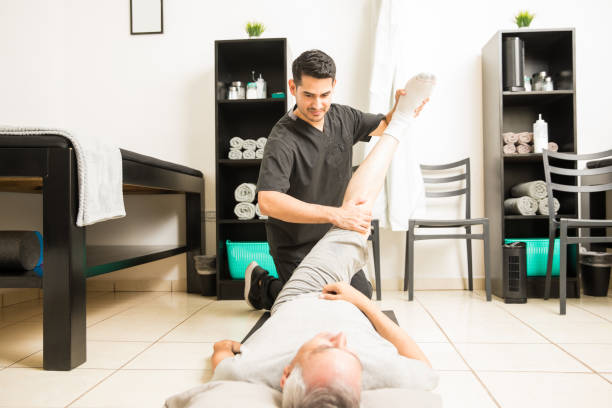 istock Physiotherapist Helping Mature Man With Leg Exercise In Clinic 1025148490