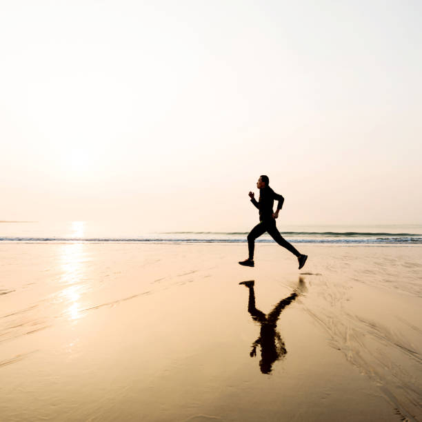 istock Man running on the beach at sunset 1025157180