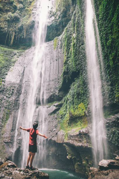 istock Man standing close to Madakaripura waterfall East Java,IndonesiaIndonesia 1025175524