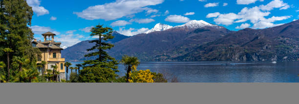 Como, Italy,Europe - April 1, 2018: view showing lake Como trees, houses, boat,  and mountains can be seen in the background in the Como area