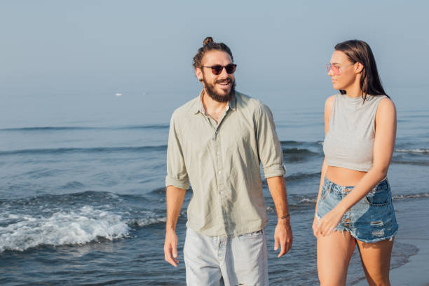 istock Pretty young couple walking at the sunny beach 1025204534