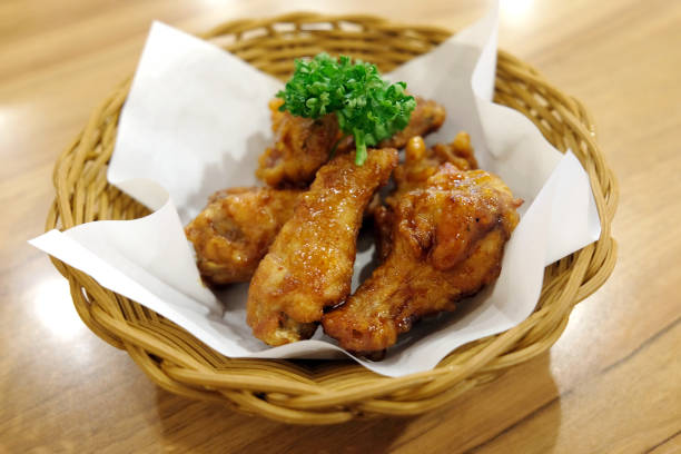 istock Fried chicken wings in white plate on wooden table. 1025204654