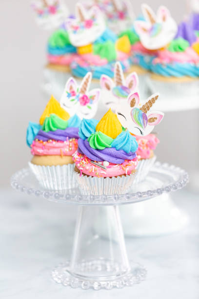 istock Unicorn cupcakes with multicolor buttercream icing on cake stands. 1025207556