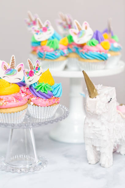 istock Unicorn cupcakes with multicolor buttercream icing on cake stands. 1025207582
