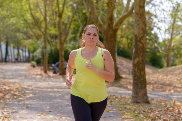 istock Determined middle-aged woman jogging in the park 1025212194