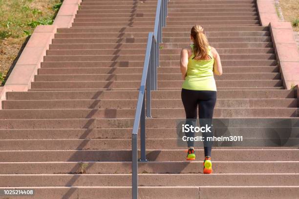 Woman Running While Climbing Stairs During Workout Stock Photo - Download Image Now - Exercising, Staircase, Overweight