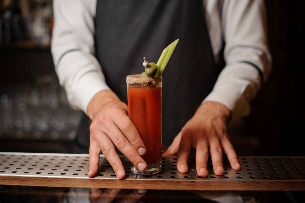 istock Bartender serving a bloody mary cocktail with two olives and celery 1025234874