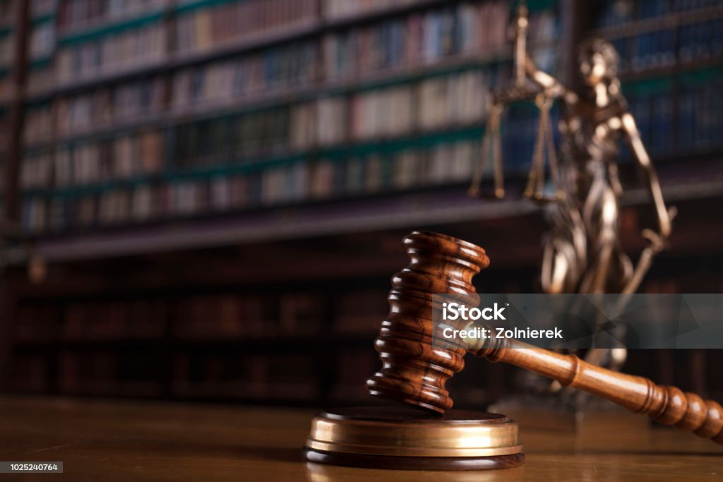 Law concept. Gavel and Themis statue in the court library. Law Stock Photo