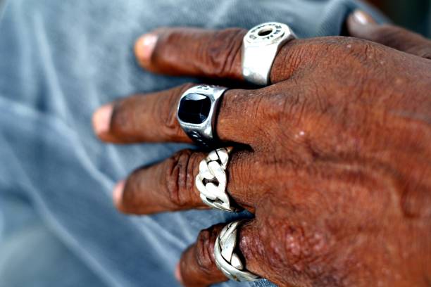 istock Hand of an old man with rings on each finger 1025247042
