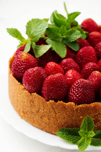 istock Cheesecake with fresh strawberries and mint on white plate on gray concrete background. Top view. 1025251890