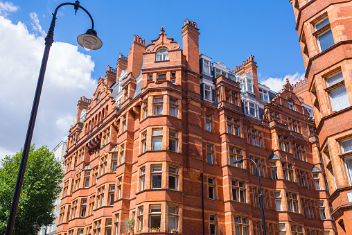 Opulent British Victorian terraced luxury residential apartments building in red bricks in Mayfair, London, UK