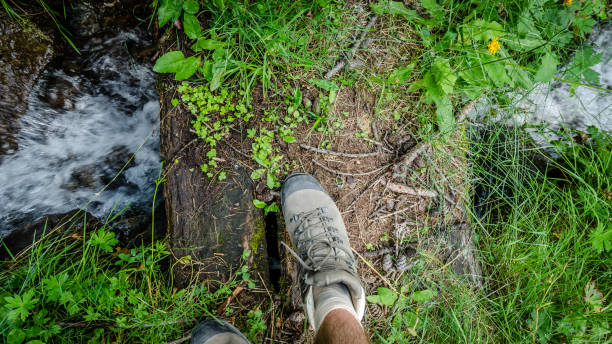 istock Walking shoe on a wooden small bridge over a quick floating river 1025268572