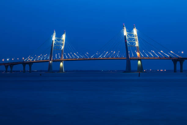 el puente de la circunvalación de autopista sobre el río neva cerca de la boca de él en la hora azul después de la puesta del sol. vista nocturna de la ciudad de petersburgo al golfo de acabado - sunset to night fotografías e imágenes de stock