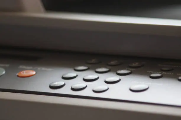 Close up of the plastic controlpanel space of a Printer with buttons and commands
