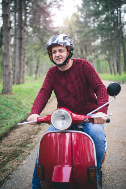 istock Young hipster man in helmet sitting on a vintage scooter . 1025299950