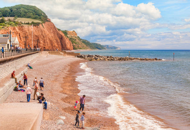 Sidmouth Beach Dorset UK 3 July 2017: Sidmouth, Dorset, England, UK - Visitors on the shingle beach on a bright summer day. jurassic coast world heritage site stock pictures, royalty-free photos & images