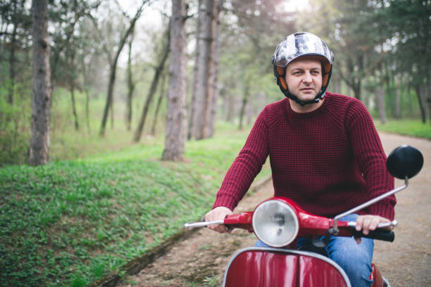 istock Young hipster man in helmet sitting on a vintage scooter . 1025305962