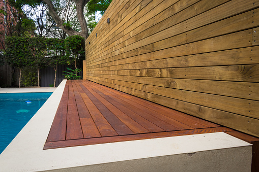 terraza de madera esgrima a lo largo de la piscina photo