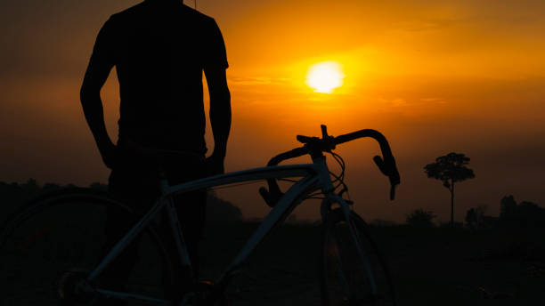 silhouette man on sunset with bike